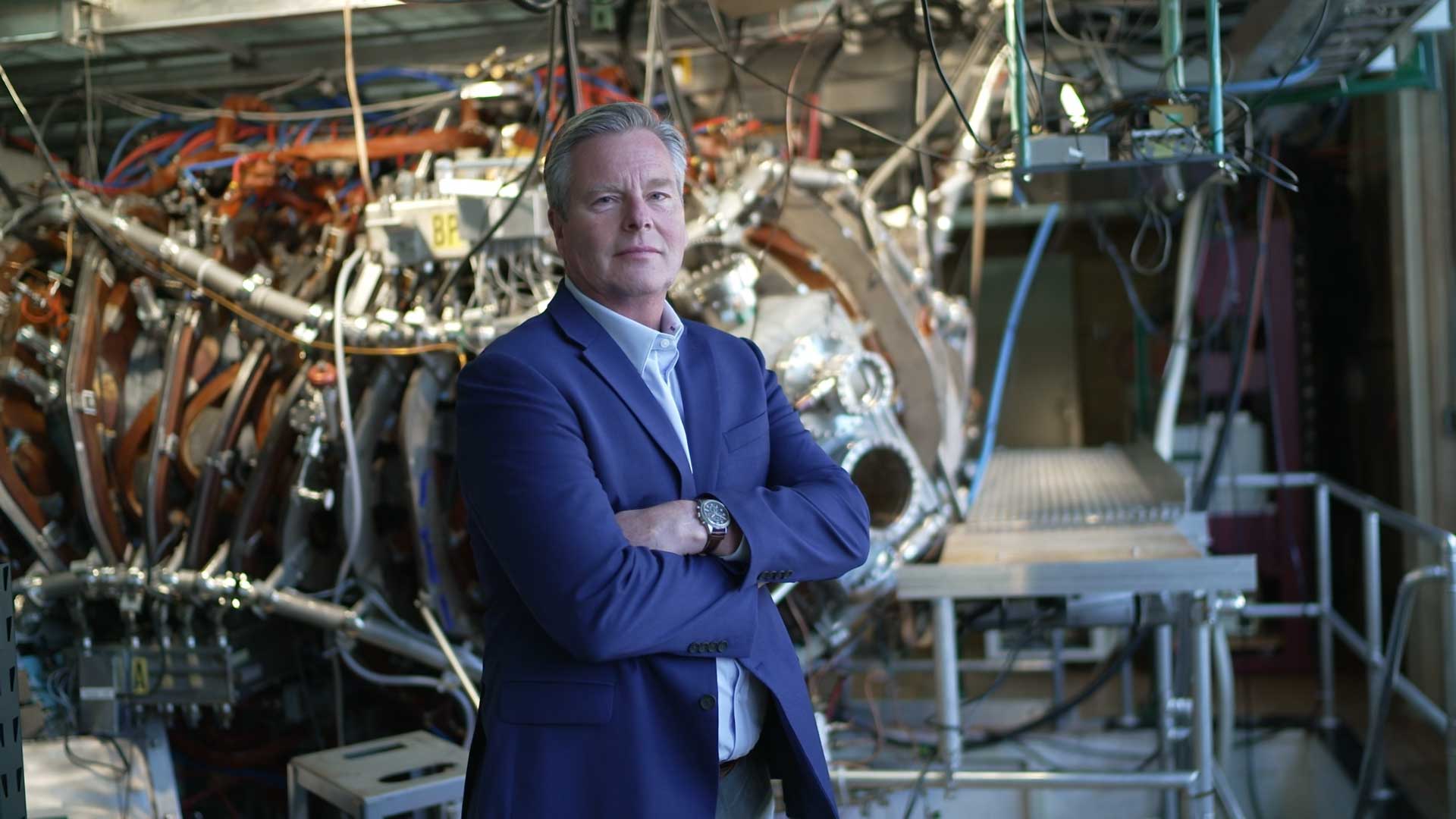 Chris Mowry standing in front of fusion technology photo