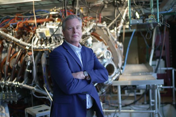 Chris Mowry standing in front of fusion technology photo